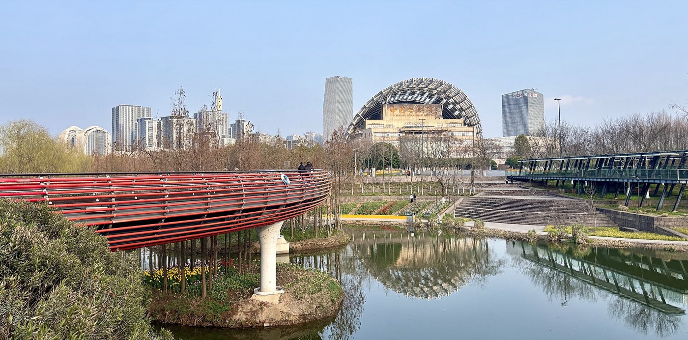 À Yanweizhou Park (Jinhua), un parc conçu pour absorber la crue au lieu de la combattre, avec ses terrasses inondables et sa passerelle rouge au-dessus de l'eau.